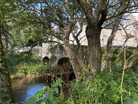 3 Photos. An old stone bridge with the Bar Brook passing underneath and a view of the cottages along the brook. Images: Roland's Travels