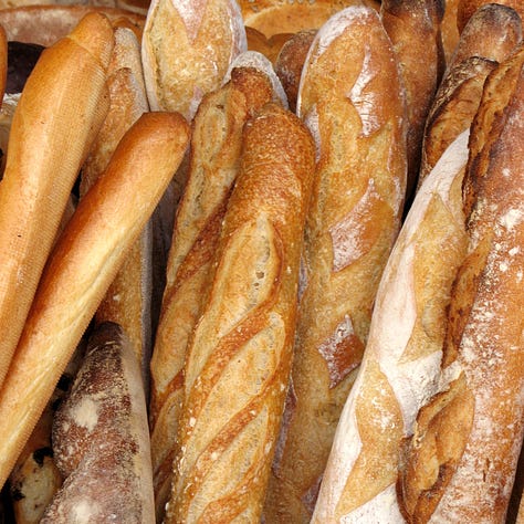A display of a variety of breads including rye and baguettes