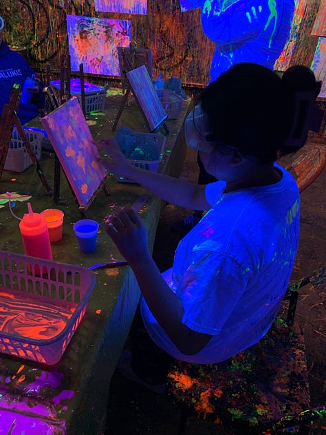 Graduate students paint their canvases and themselves with psychedelic neon paint