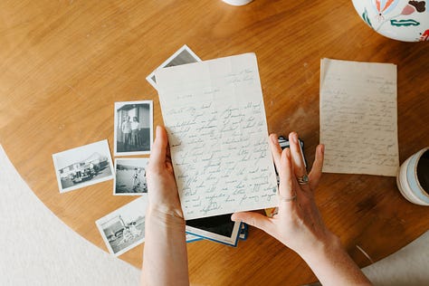 old letters, photographs and slides on a wooden table