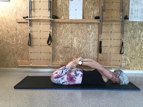 woman on Pilates mat executing the Rocking
