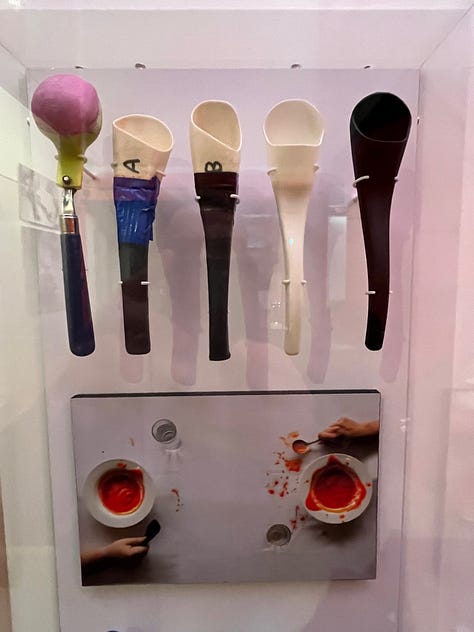 A selection of items on the wall at London's Design Museum including a yellow lemon press, an iconic Phillipe Starck bottle opener, some ice cream scoops, spoons, a hanging wall of classic deisgns and a Chemex pour over glass coffee maker.