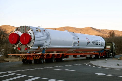 The Long March 6A's fairing during stacking, the first-stage heading to the launch site, and the first and second stage being prepared for stacking.