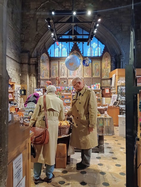 Exterior side of stone building with clock tower, interior with large stained glass window, interior with smaller stanined glass windows, altar, and ceiling decoration that looks like large star, large star, gift shop fll of merch in side chapel, cake slice and cup of tea