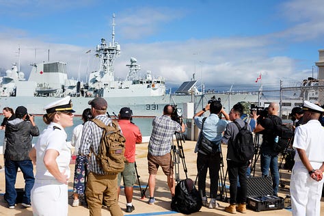 In-port naval open house images including a press conference. One image of the USS Carl Vinson steaming out of Pearl Harbor as a passanger jet takes of at HNL.