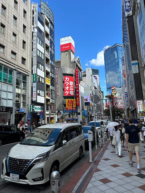 Pictures of soba, Tokyo citscapes, robots, Tokyo girls dressed in Maid outfits, my hand on LB's shoulder, Tokyo Tower, Robot greeters, two Issey Miyake mannequins, a cabinet of Japanese food supplies, and the side entrance of Sensoji Temple