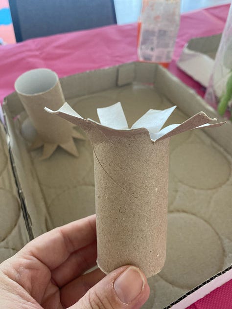 Photos of cardboard tubes snipped at the ends to create flower shapes ready to dip into paint