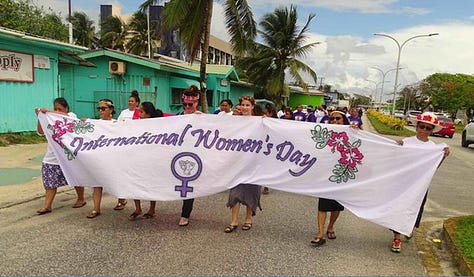 Colourful images of women from Pacific, India, Africa and the US at women's right protests with banners and placards featuring the women's sign as well as badges, singlets and posters with the same symbol. 