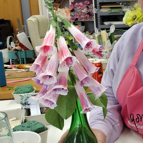 Pink paper foxglove, a handful of foxglove florets, a finished paper foxglove with pink and purple painterly florets.