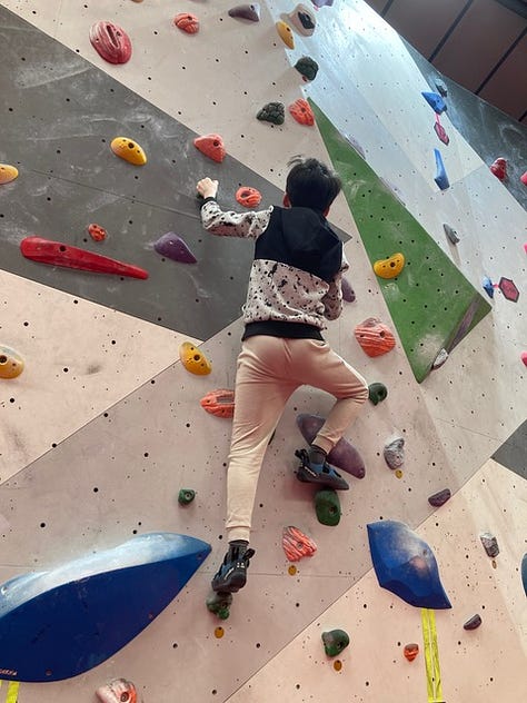 A woman and a boy on a bouldering climbing wall