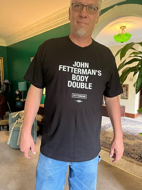 Shy in HARD WORKING RURAL DEMOCRAT tee; in PROTECT TRANS KIDS tee; and in JOHN FETTERMAN'S BODY DOUBLE tee
