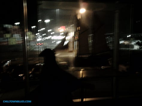 Picture 1: Slightly out of focus image of a pigeon figurine with (relative to pigeon's size) an old-fashioned merchant ship seemingly floating in the background. Picture 2: In a dimly light room, the shadow of a picture on a ledge or ledge-like bar is pictured on a wall. CHILLTOWNBLUES.COM is in turquoise blue on bottom left of image. Picture 3: A nighttime photo by Chilltown Blues of a statue (by sculptor Alvin Pettit) of civil rights activist and educator Mary McCleod Bethune on redlined south side of Jersey City. Just behind the nine-foot bronze tall statue is a small park named for her. Since the photo is taken through glass, tricks of the light make it appear as if there's little floating orbs of light all around everything. The whole thing looks bluesy, partially because sky has deep blue tint.. Picture 4: What looks like the bust of a gray pigeon looks out of a window at an urban landscape: there's the rear of a black car almost parked by the crosswalk but not quite. And across the street hung just below streetlight fixtures are, respectively, one large glowing white snowflake ornament; and about 40 feet behind it, another one across the street. CHILLTOWNBLUES.COM is written in a bright blue on the bottom right of image. Picture 5: A sepia-toned black and white image of a table with a pigeon figurine in front of a large empty birdcage. Picture 6: Picture of an old=fashioned light fixture with three curved hooks that support bulbs underneath little red lampshades. They come from a fixture that has two hooks on each side of it as well. Nestled in the center hook is a pigeon figurine. The color of the wall behind it is orange and the light from the three bulbs has a bird-like silhouette. In the bottom left corner in black is "chilltownblues.com." Picture 7: Pictured taken in a dark room of (from foreground going outward) a pigeon silhouette, mid-left, the silhouette of a bigger ship miniature on the right and then outside of large windows many lights from a big parking lot. Picture 8: Photograph of a pigeon's silhouette on the bottom left, foreground, taking about a fifth of a nighttime photo of trees with mostly yellow leaves in the background swirling toward a bright white street light. On the right side, there's a post with a series of blight lights mid-ground in the photo. Picture 9: The ChilltownBlues.com pigeon is standing in the midst of a jigsaw puzzle that's mostly done. To the left of it, from the viewer's perspective, is a kind of watermelon pie, where the eyes are half-kiwis, an orange wedge for a noise and a dark string of berries for a smile. All around the smile and the pigeon are the other puzzle pieces of which it's unclear what the rest make out, though it's mostly fruit.