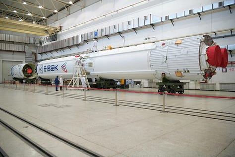 The Long March 6A's fairing during stacking, the first-stage heading to the launch site, and the first and second stage being prepared for stacking.