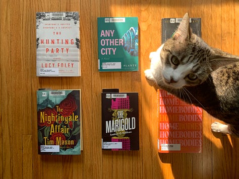 Three images of six library books and a grey and white cat in part of the frame.