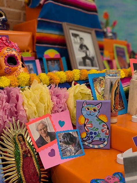 Colorful Day of the Dead altar with candles, flowers, and offerings.