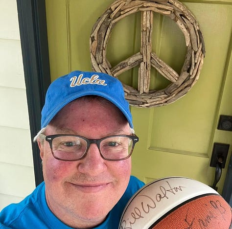 Kacey is holding Bill Walton autographed basketball, Mick Cronin statement, and social media post