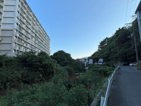 Pictures of riverside, a train leaving a small station, a passageway so small it looks like a culvert, and the suburbs of Kobe