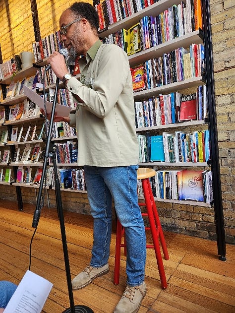 Various poets standing or sitting in Milkweed Bookstore, in front of filled bookcases, reading poetry.