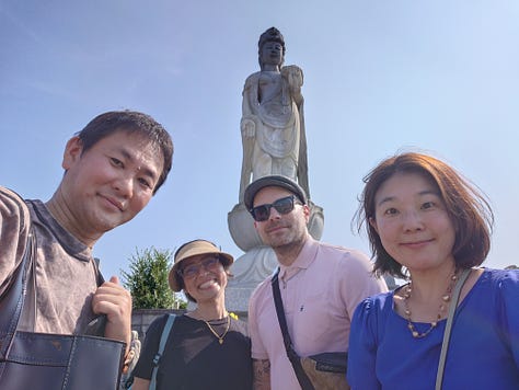 9 pictures of Jackson, his wife, his Japanese cousin, Eikichi, and Eikichi's wife, Megumi, together, visiting the ancestral grave in Iyo City, walking around Matsuyama, eating dinner with Uncle Kazuya, leaving the train station, eating Oden in Ginza, posing with Lin-Chan, the Japanese poodle, and pictures of Jackson and Erika taking pictures of the Tokyo skyline