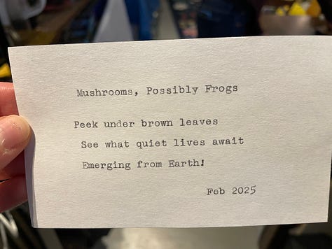 Typewriter set up on a card table in a bookshop and three index cards with haiku on them.