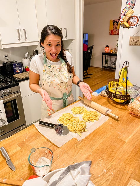 Photo of a paved walking trail surrounded by lush vegetation and a deer on one side, a round embroidery hoop with an image of a pineapple, a woman smiling and presenting the piles of fresh pasta she made from scratch, a selfie photo of woman and her dad painting a piece of furniture, a photo of a woman and her mom sitting on the floor painting a piece of furniture, a selfie photo of a woman and her parents sitting down at the dinner table to eat barbecue food, a photo of a woman and her dog looking out the window, a photo of a LOVE sign in a grassy, woody green forest, a selfie photo of a woman with her parents and dog behind her walking in the opposite direction.