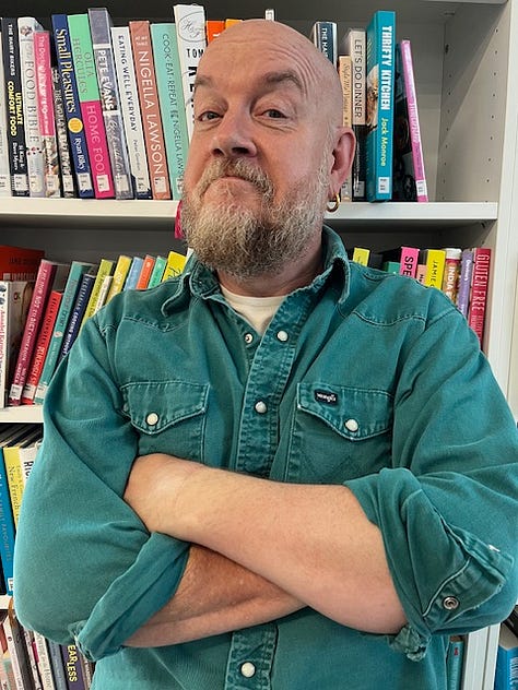 Three photos of comedian George Egg standing in front of a bookshelf of cook books, wearing a green shirt and with his arms crossed.