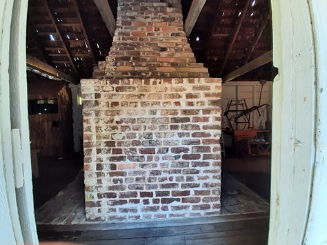 A small white building with a shingle roof that is the slave quarters at Hopsewee. Second and third photos show the large brick center fireplace.