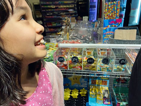 Left: girl standing in front of candy bins. Middle: open shelves with Care Bears, My Little Ponies, and other toys. Right: open shelves with Lite-Brites and other classic toys.