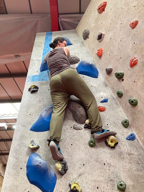 A woman and a boy on a bouldering climbing wall