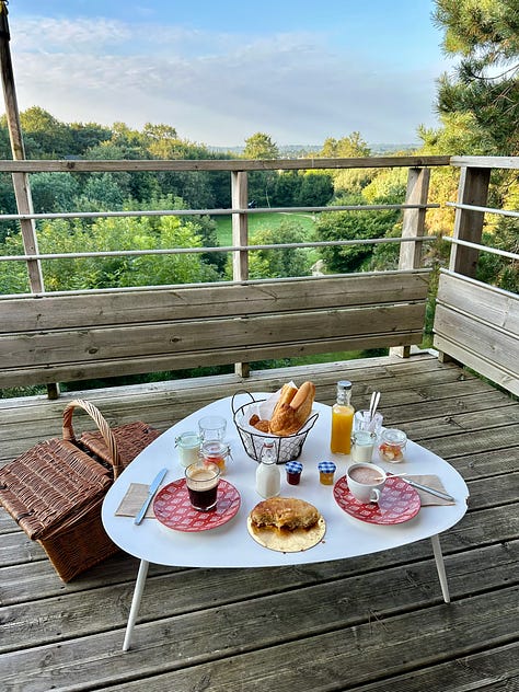 an evening harbor filled with boats; restaurant sign offering oysters and wine, a seafood platter; a breakfast picnic basket