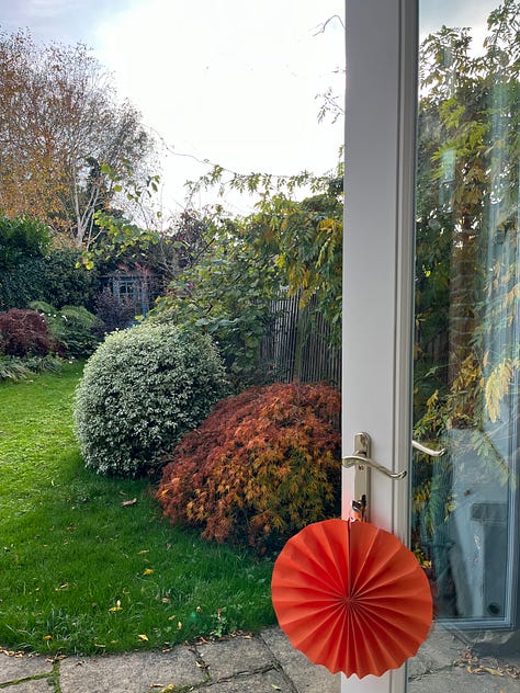 Autumn at home — paper pleated decorations, afternoon light, a dusting of snow.