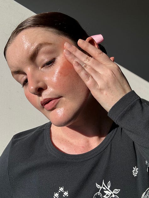 Morgan applies a cream peach blush to her cheeks and uses fingers to blend them out