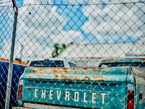 an old Chevy truck photographed through a fence