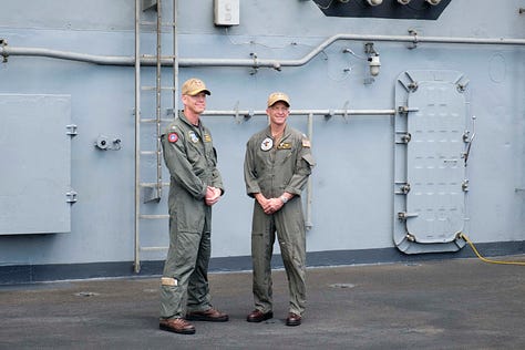 In-port naval open house images including a press conference. One image of the USS Carl Vinson steaming out of Pearl Harbor as a passanger jet takes of at HNL.