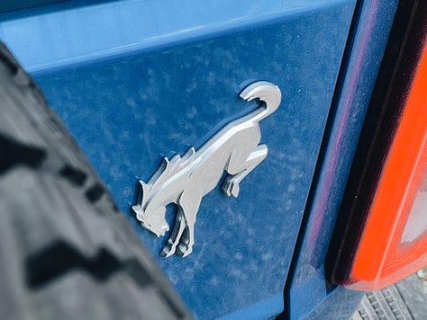 2022 Ford Bronco Badlands details, including side badge, windshield text, rear horse badge, front load points, and side fender flares