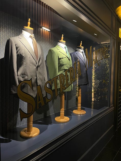 First image: line of suits in a windowcase. Second image: curated bookcase. Third image: a cocktail in a coupe.