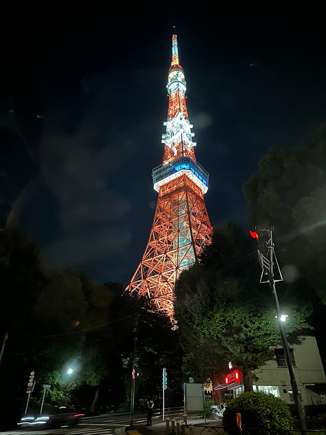 Pictures of soba, Tokyo citscapes, robots, Tokyo girls dressed in Maid outfits, my hand on LB's shoulder, Tokyo Tower, Robot greeters, two Issey Miyake mannequins, a cabinet of Japanese food supplies, and the side entrance of Sensoji Temple