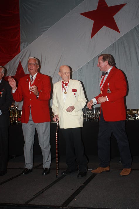 Ed smiling in 3 photos: one wearing medals and with a trophy in background, one in a large meeting, and one on stage being recognized by 2 other men