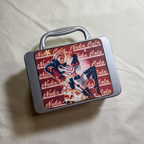 Silver lunchbox with nuka cola stickers