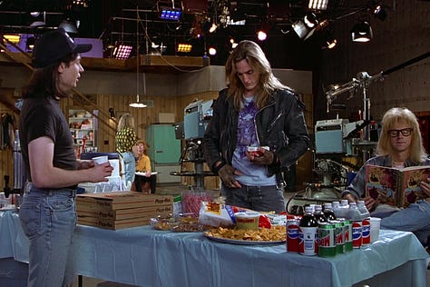 Mike Meyers with a box of Pizza Hut Pizza in the Product Placement scene in Wayne’s World (1992) with Rob Lowe | Film Flavor: A Newsletter Surveying Food in Film