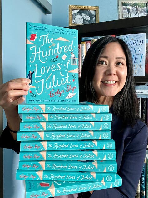 Author Evelyn Skye trying--and failing--to balance the giant stack of THE HUNDRED LOVES OF JULIET paperbacks