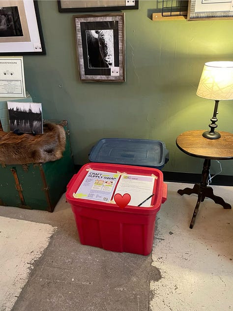 Swap tubs in a retail store, empty tables arranged in a basement, the same tables beginning to fill with materials, and a wide range of donated supplies on those tables from paint to frames.