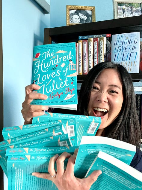 Author Evelyn Skye trying--and failing--to balance the giant stack of THE HUNDRED LOVES OF JULIET paperbacks