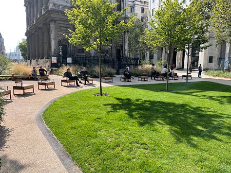 Pictures of the Strand Aldwych scheme. Many of the pictures are of pedestrian spaces, with extensive planting throughout and trees. People are walking in the street, and sitting at provided benches. There is one picture with someone on a bicycle, and another picture with my outside the disused Strand station