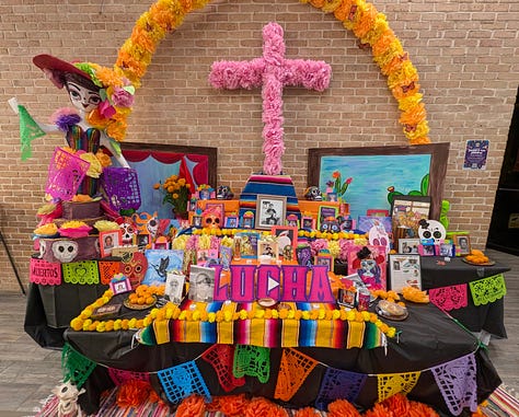 Colorful Day of the Dead altar with candles, flowers, and offerings.