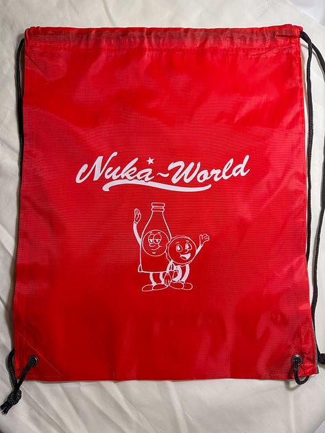 Red and black drawstring bags with Nuka World and picture of Bottle and Cappy