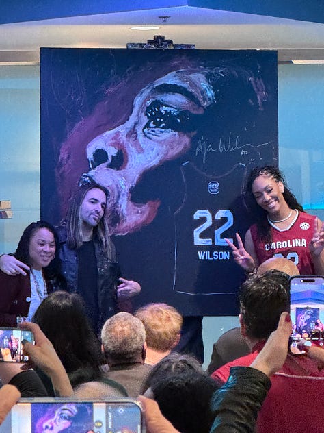 Me and A'ja's statue; custom art of A'ja; Dawn Staley, the artist of the painting shown, and A'ja; poster from the event I attended; A'ja decal on the arena; me and Janel; posing in my A'One shirt; A'ja's retired jersey; Dawn Staley Way