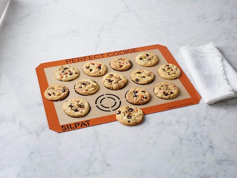 From left: Silpat cookie sheet, the cover of the Crumbs cookbook, cookie stamps with cookie dough and unbaked cookies.