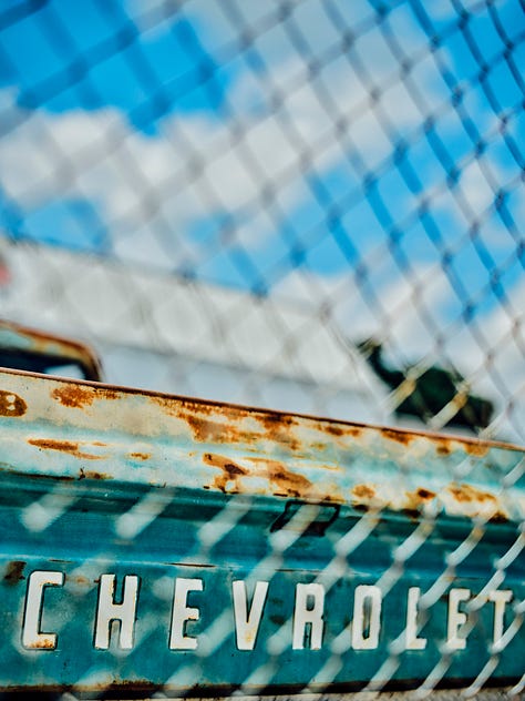 an old Chevy truck photographed through a fence