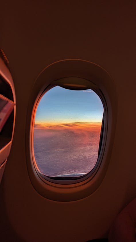 Three images: the white wing of the plane, tipped with red, high above a frozen river and mountains below. Also a silhouette of a plane window framing a vibrant, rainbow-stripe sunrise over white clouds. Last, a neon orange square of light cuts across a paragraph of Thin Places by Kerri Ni Dochertaigh.